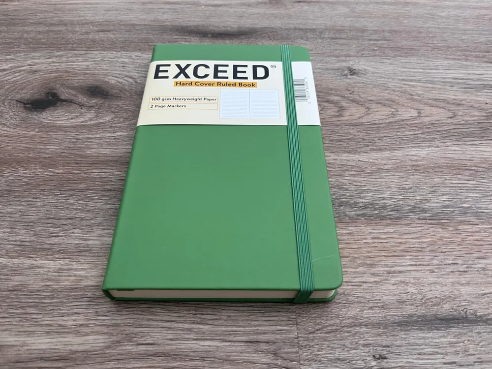 EXCEED hard cover ruled journal notebook lying on the ground